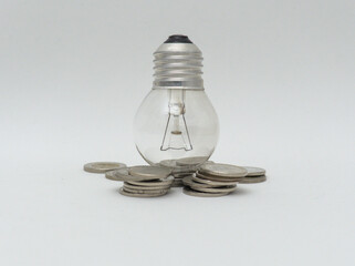 Isolated Bulb with coins. Money spent with light bulbs. Concept of energy efficiency