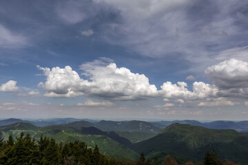 many shades of mountains with beautiful white clouds on the sky