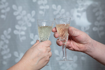 Cropped photo, Hands and champagne glasses. Man and woman are mated with glasses