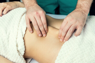 Fototapeta na wymiar Hands of a masseur's man doing a massage of the abdomen.