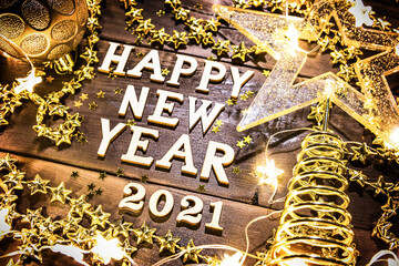 Happy New Year-wooden letters on a festive background with sequins, stars, lights of garlands. Greetings, postcard.