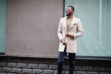 Stylish african american man wear beige jacket with sunglasses.