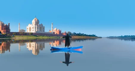 Deurstickers Young girl in traditional black dress raised her arms, Panoramic view of Taj Mahal in the background - Agra, India © muratart