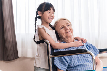 Asian Lovely girl visit and encourage grandmother on patient wheel chair in hospital