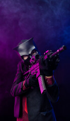 Fototapeta na wymiar a man wearing a demon skull mask in a leather cloak with an airsoft gun