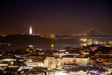 Lisbon, Portugal at night. Winter solstice 2020. Long exposure. View of the 25th April bridge and Christ the King