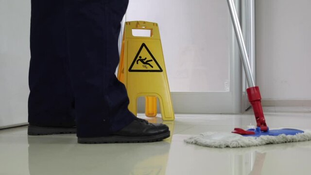 Cleaning Floor With Caution Wet Floor Sign In Office with mob slow motion