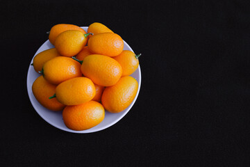 little oranges kumquats in a bowl 
