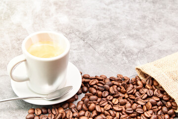 Background from coffee grains and a cup from coffee, the top view
