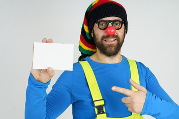 Fototapeta premium A clown in a bright costume holds a sign for the inscription.