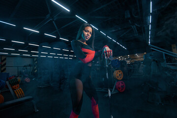 Fototapeta na wymiar Muscular young fitness sports woman workout with barbell in fitness gym.