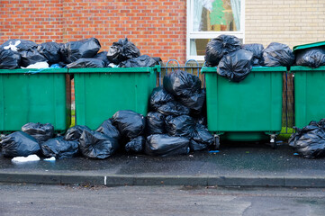 Fly tipping of waste and rubbish black bin bags in residential area