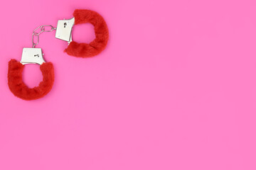 Pink fluffy handcuff on a pink background. Valentine's day. Space for text