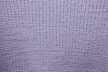 Simple knitted texture of a light lilac sweater with lurex.