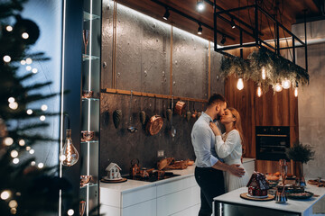 The guy and the girl celebrate the New Year. A married couple retired in a cozy studio setting. Location in the kitchen.