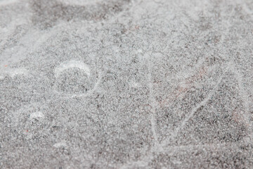 Cracked ice on concrete with yellow leaves. Yellow leaves and concrete can be seen under the cracked ice