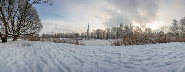 Panoramic view of covered in snow park in winter. View of frosty lake in snowy park.