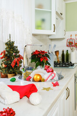 Christmas toys and unwashed dishes in kitchen sink, Santa hat after Christmas and New Year celebration in morning. Vertical orientation, selective focus 