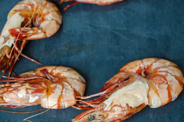 Tiger prawn shrimp grilled on black plate seafood background