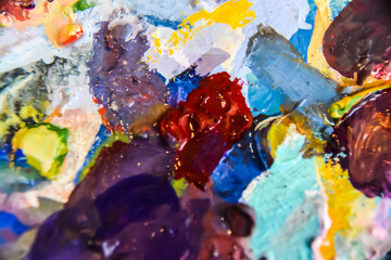 multicolored palette with pieces of oil acrylic paint macro abstraction background