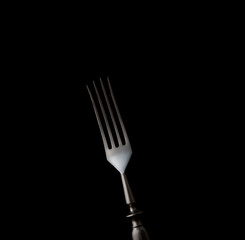 Dining fork isolated on black background with