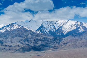 Beautiful landscape of Himalayas barren mountains with white snow, and blue sky,  in Ladakh, Kashmir, view from Thiksey Monastery or Thiksey Gompa.