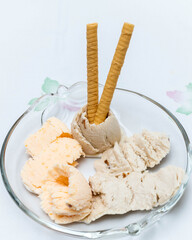 Vertical view of mandarin ice cream. Banana and rum ice cream with sultanas and two wafers served on a glass plate