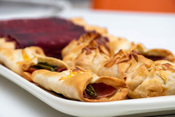 Horizontal macro view of canapés and sachets with vegetables and ham and some waiter's tongs. healthy food, Mediterranean diet