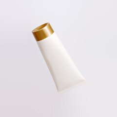 Layout white cosmetic tube with golden cap isolated on a white background