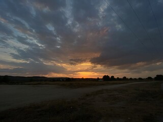 atardecer de campo, con sol hundiendose entre mancha amarillenta