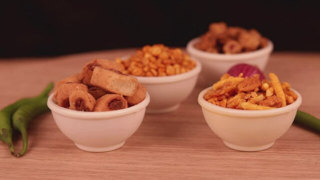 shing bhujia and chanadal with bhakharvadi on wooden table,Indian Namkeen indian food in white bowl in white background,Namkeen in a bowl wooden background,