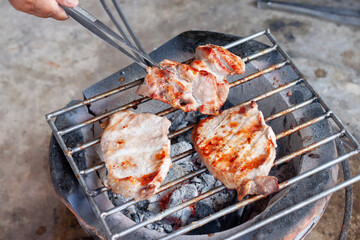 Grilled pork on the grille on the vintage stove in the kitchen of the countryside.