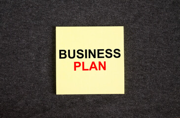 Yellow sticker on the dark gray texture background with text Business Plan
