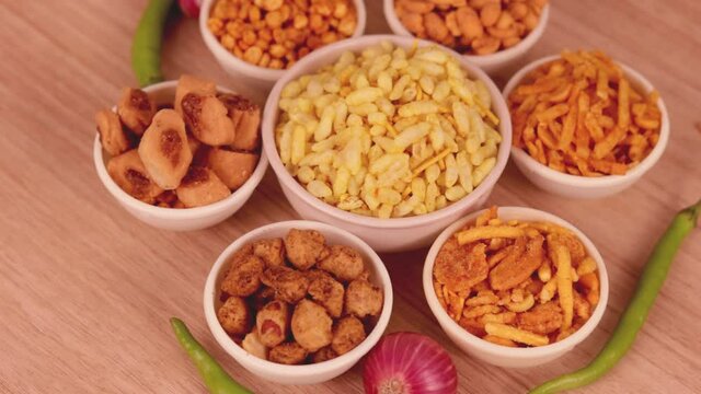 indian traditional deep fried salty dish - chivda or mixture or farsan or farsaan and Namkeen snacks on wooden teblet,Gujarati Mix - Chiwda a variable mixture of spicy dried ingredients