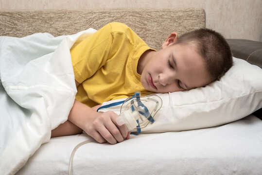 A sick teenager at home with a breathing mask lies sideways on the couch. In a yellow T-shirt.