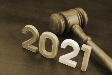 Wooden gavel and numbers 2021 on wooden table. Concept of new  rules.