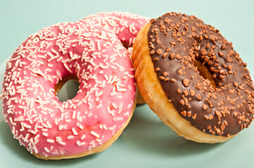 three donuts or doughnuts on aquamarine plate in simple graphic style