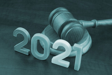 Wooden gavel and numbers 2021 on wooden table. Concept of new  rules.