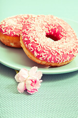 pink donut doughnut with a pink flower over aquamarine background in graphic style