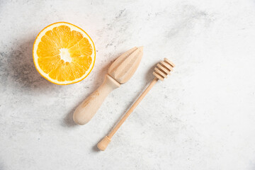 Obraz na płótnie Canvas A slice of fresh orange with wooden utensils