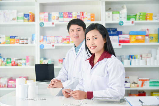 Asian professional young pharmacists standing with smile at drugstore.