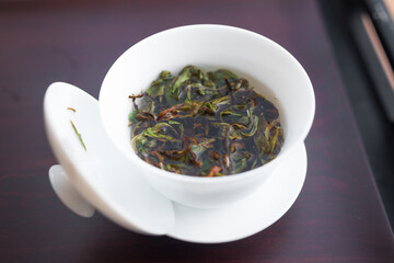 Rare high grade aged white tea steeping in a gaiwan with hot water. Beautiful full leaves processed by one of the best tea master in the world. Gong Fu Cha brewing, eastern style.