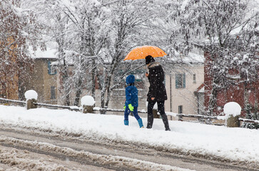 Mamma con bambino camminano sulla neve a Monza, Lombardia, Italia. 28-12-2020