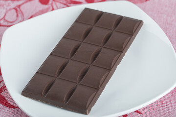 Bar of delicious chocolate on a white plate