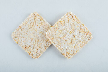 Two delicious airy crispbread on white background