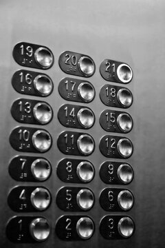 Floor buttons in elevator with number 21 twenty-one pressed. Chrome control panel for elevator movement close-up in multi-storey building. Traffic, transportation. Lots of buttons on elevator wall
