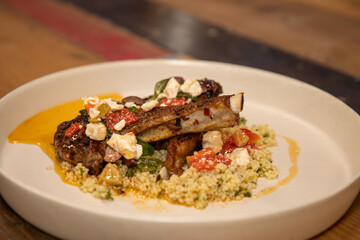 A delicious plate of Grilled Lamb Chops with spiced Couscous on a wooden kitchen work top