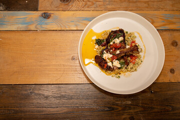 A delicious plate of Grilled Lamb Chops with spiced Couscous on a wooden kitchen work top