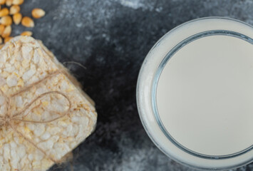 Stack of crispbread and glass of milk on marble background