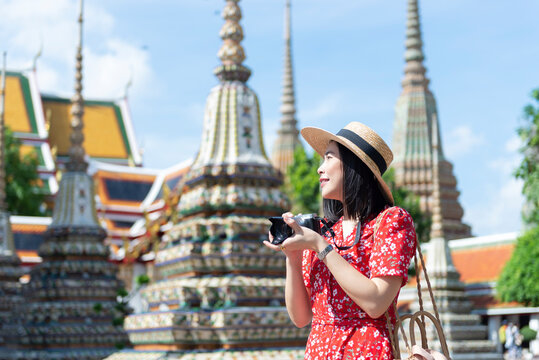 Asian Girl Tourist is visiting Wat Pho or the Reclining Buddha Temple, one of the most-visited attraction in Bangkok, Thailand.